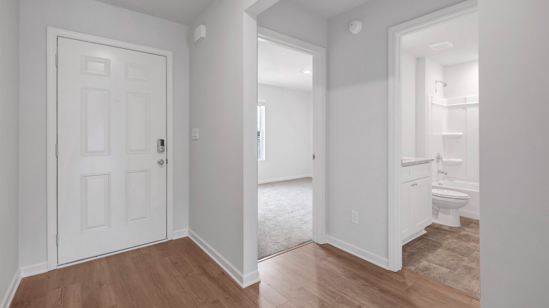 Front door entryway leading into the secondary bedrooms o the kitchen area