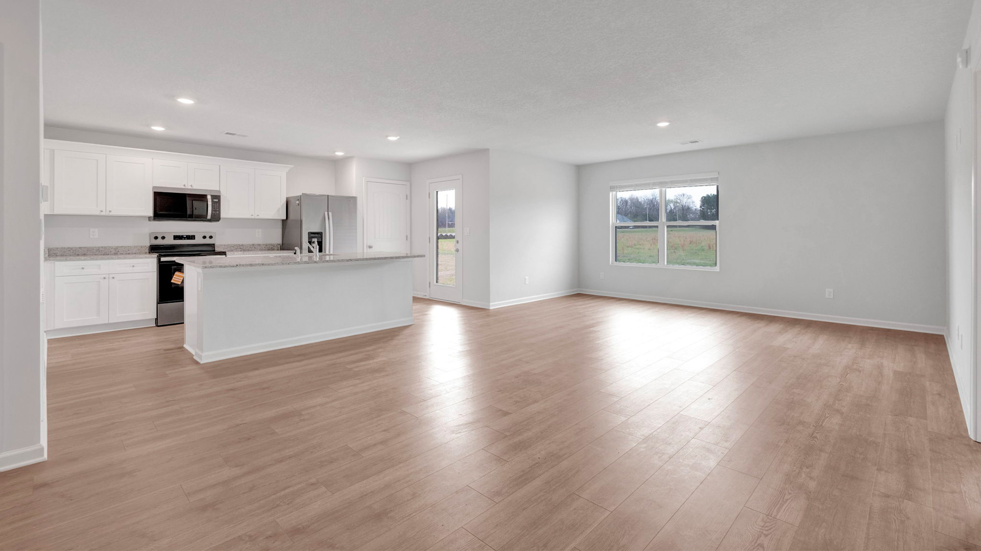 Open concept view of the dining room overlooking the living and kitchen area
