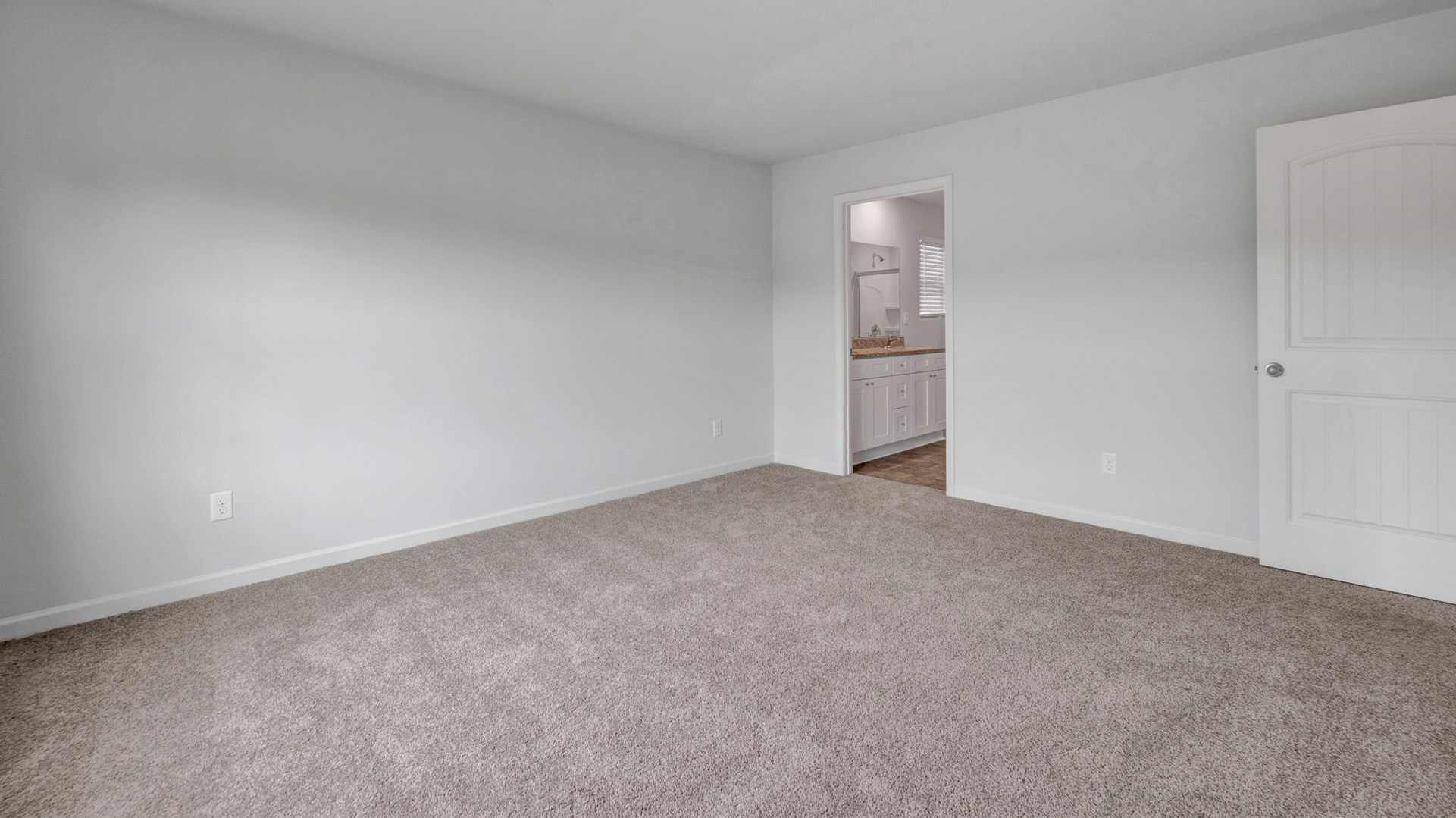 Primary bedroom with carpet flooring and neutral paint