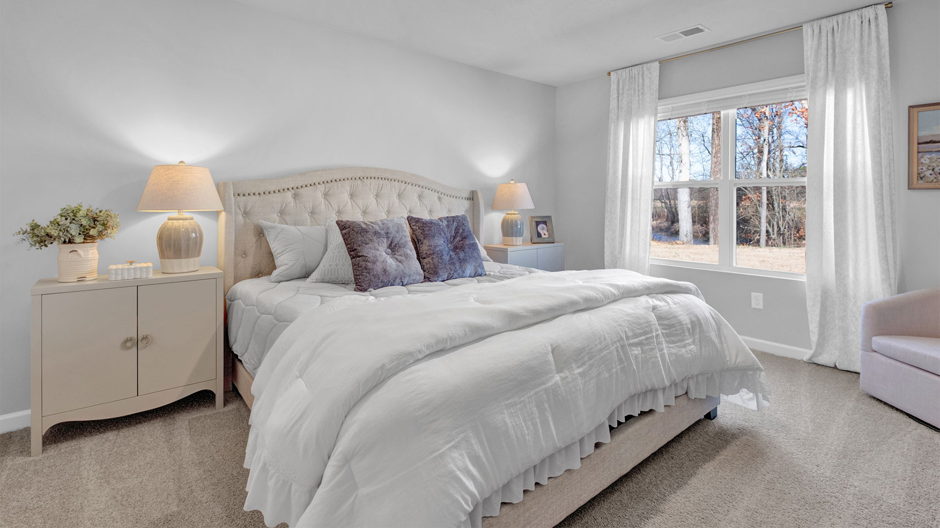 Primary bedroom with a large double window overlooking the backyard