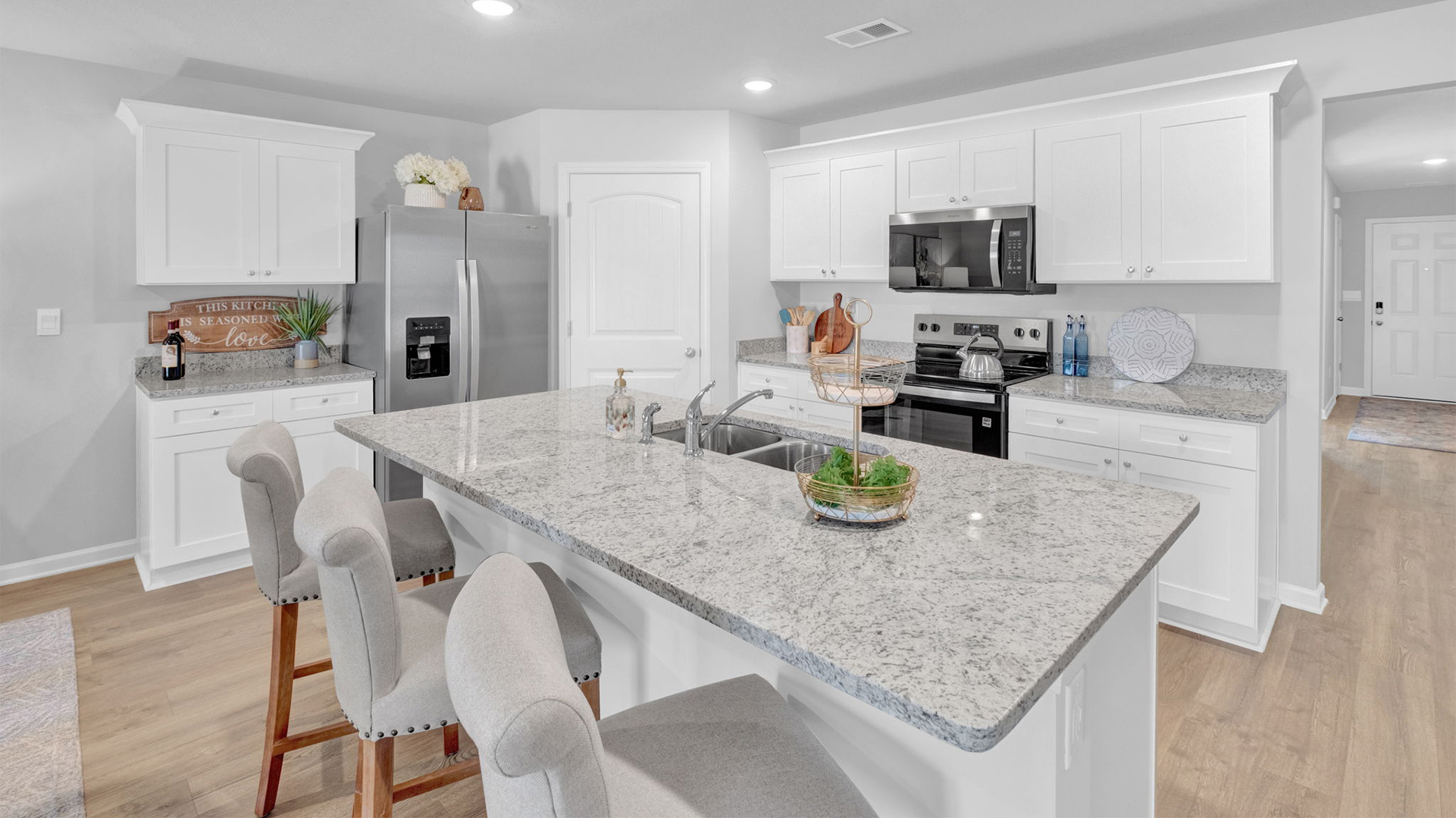 Beautiful kitchen op0ens up at the end of entry hall