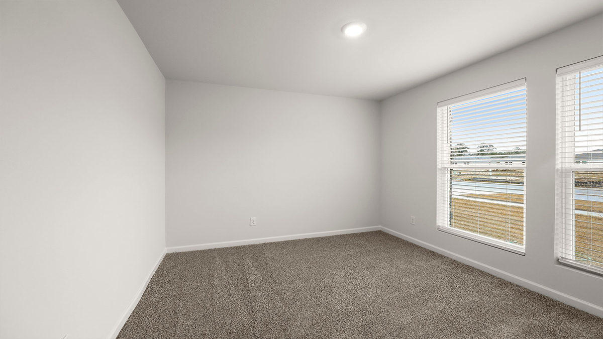Second bedroom with carpet flooring and two large windows