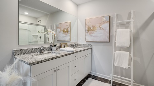 En suite primary bathroom with a glass enclosed walk in shower