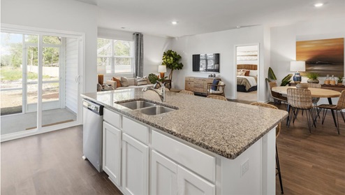 kerry plan kitchen island overlooking dining and living room in fitzgerald crossing community