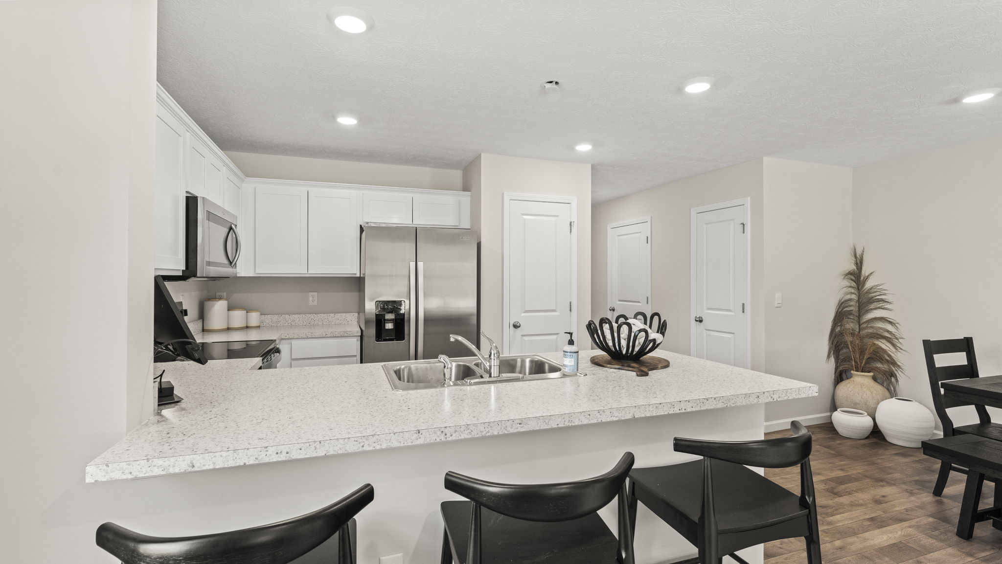 Beautiful kitchen area with LED lighting shining on the light cabinets