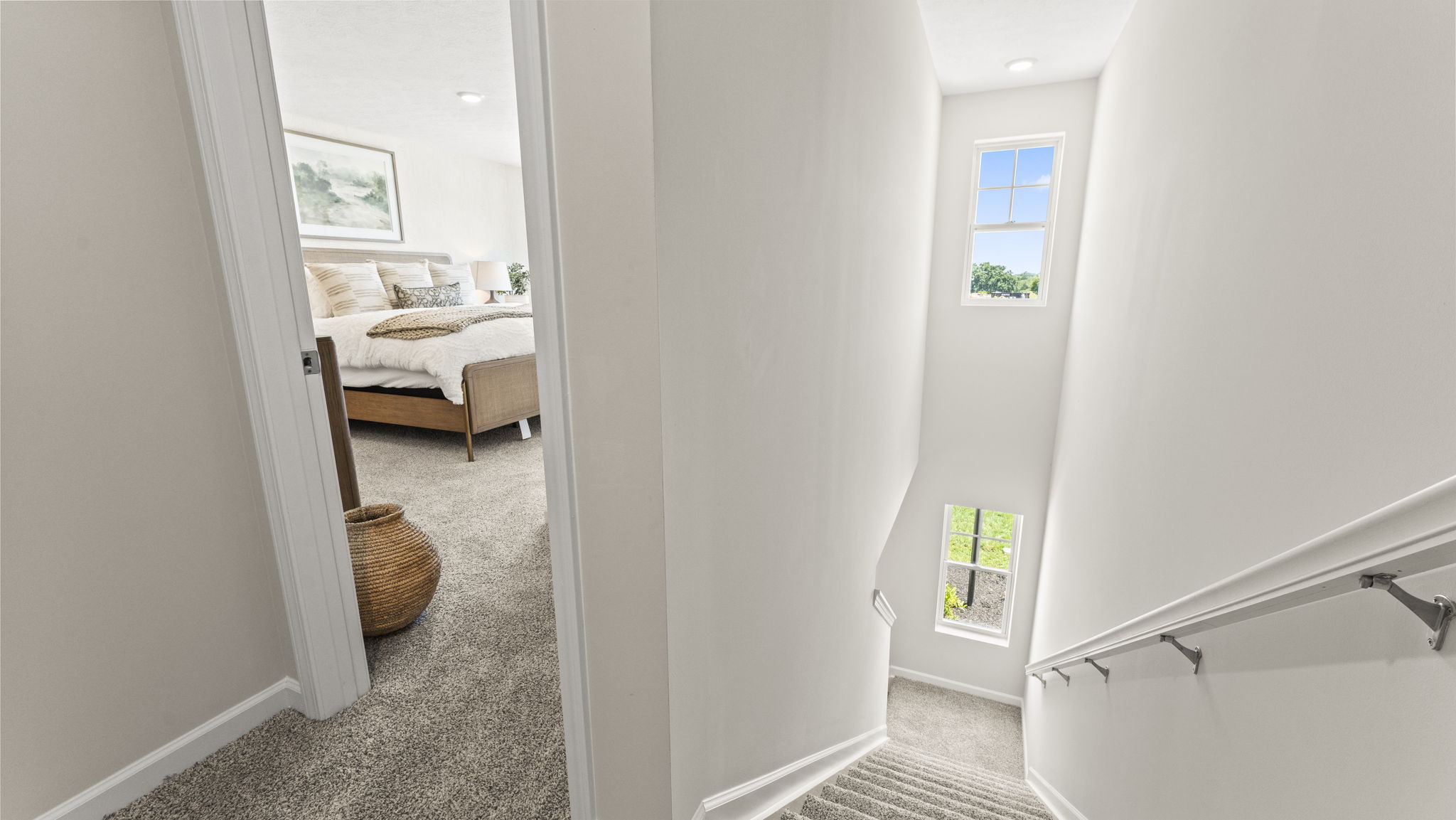 Second story view of the staircase with natural light coming from accent windows