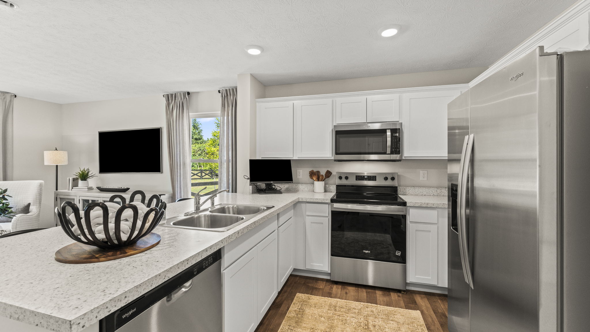Kitchen area has beautiful light cabinets and stainless steel appliances