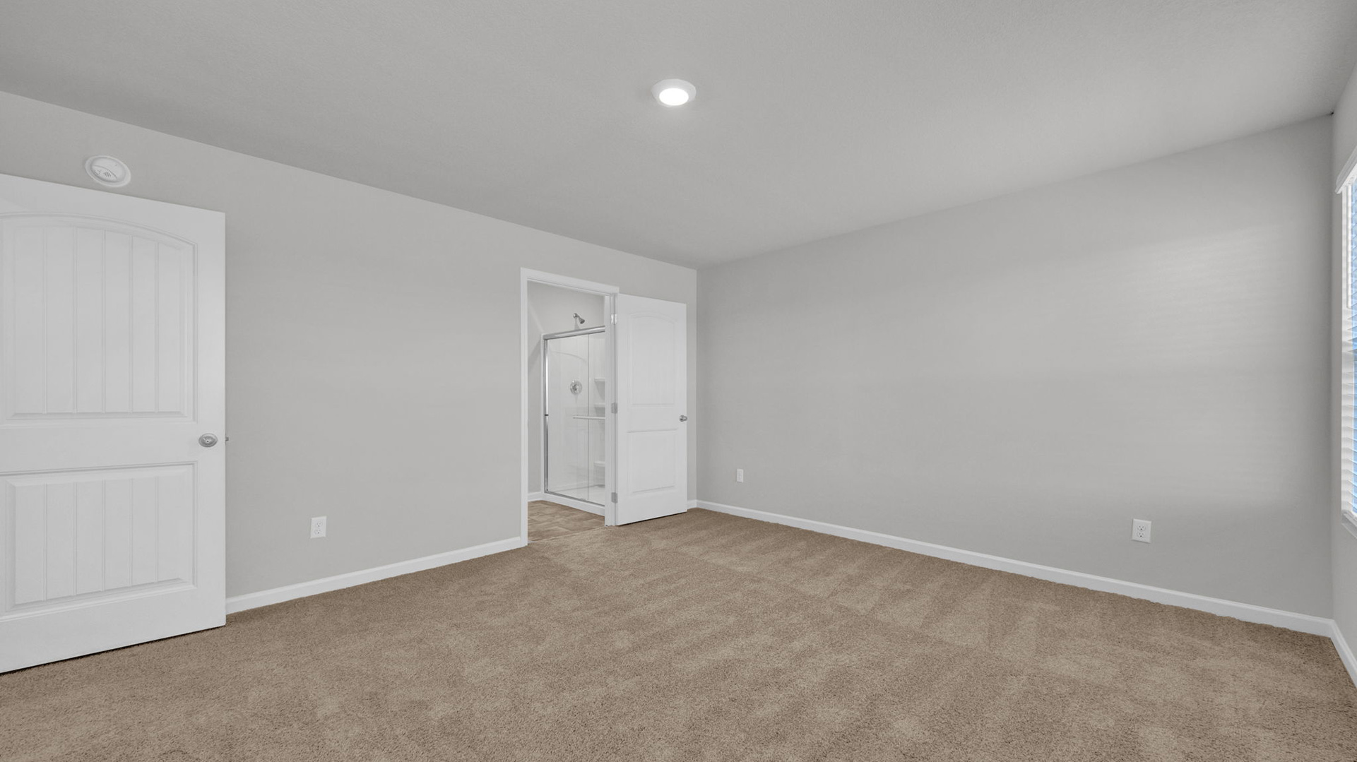 Primary bedroom with carpet flooring and neutral paint