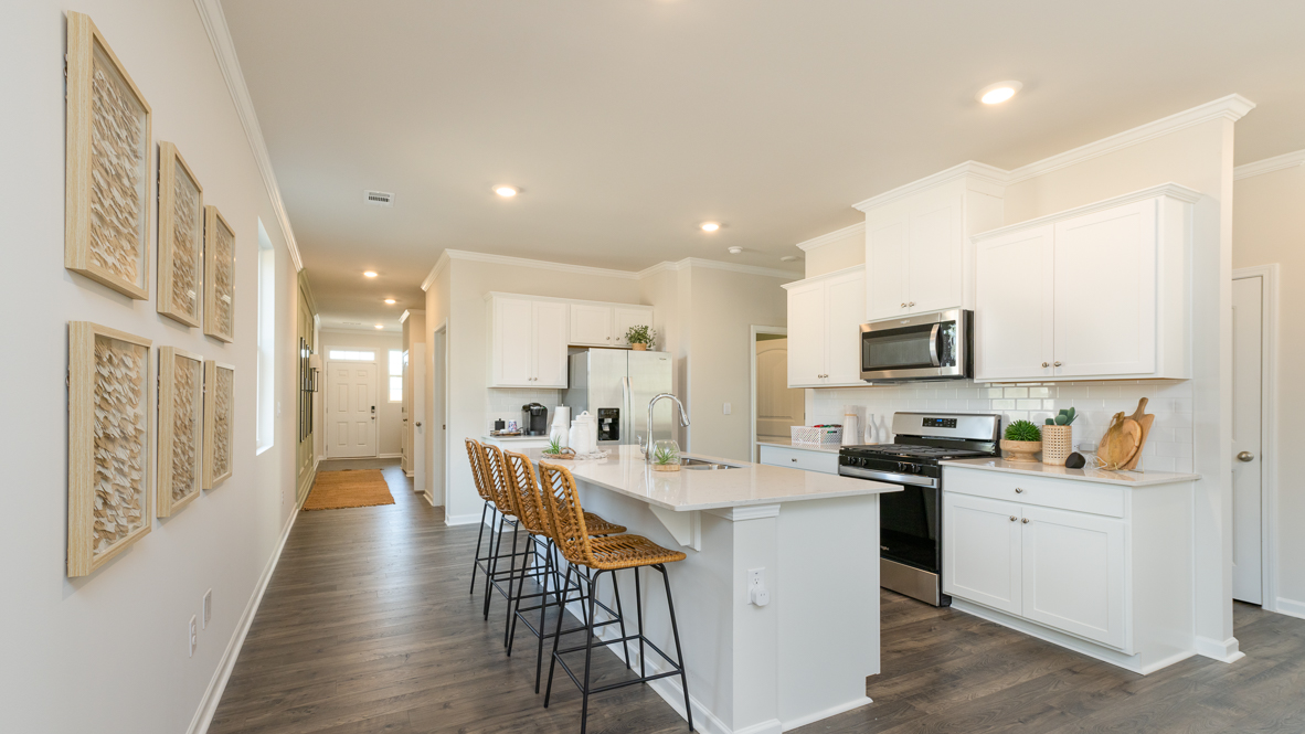 Beautiful kitchen area with light cabinets and stainless steel appliances