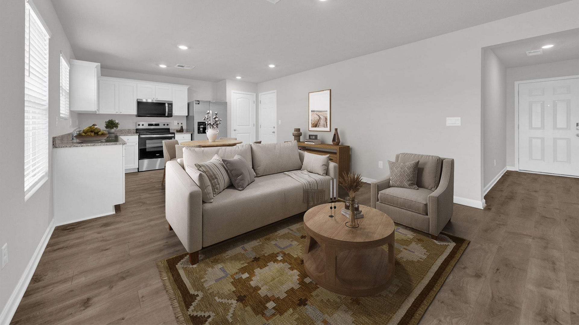 Living room area opening up at the front door with the kitchen and living area open to one another