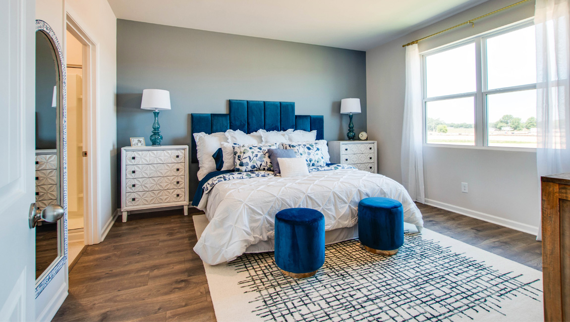 Primary bedroom with neutral walls and carpet flooring