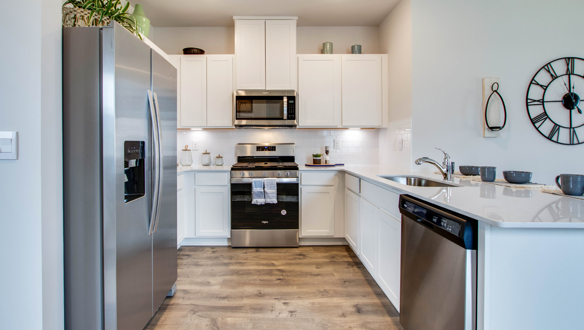 Kitchen area with light cabinets and stainless steel appliances
