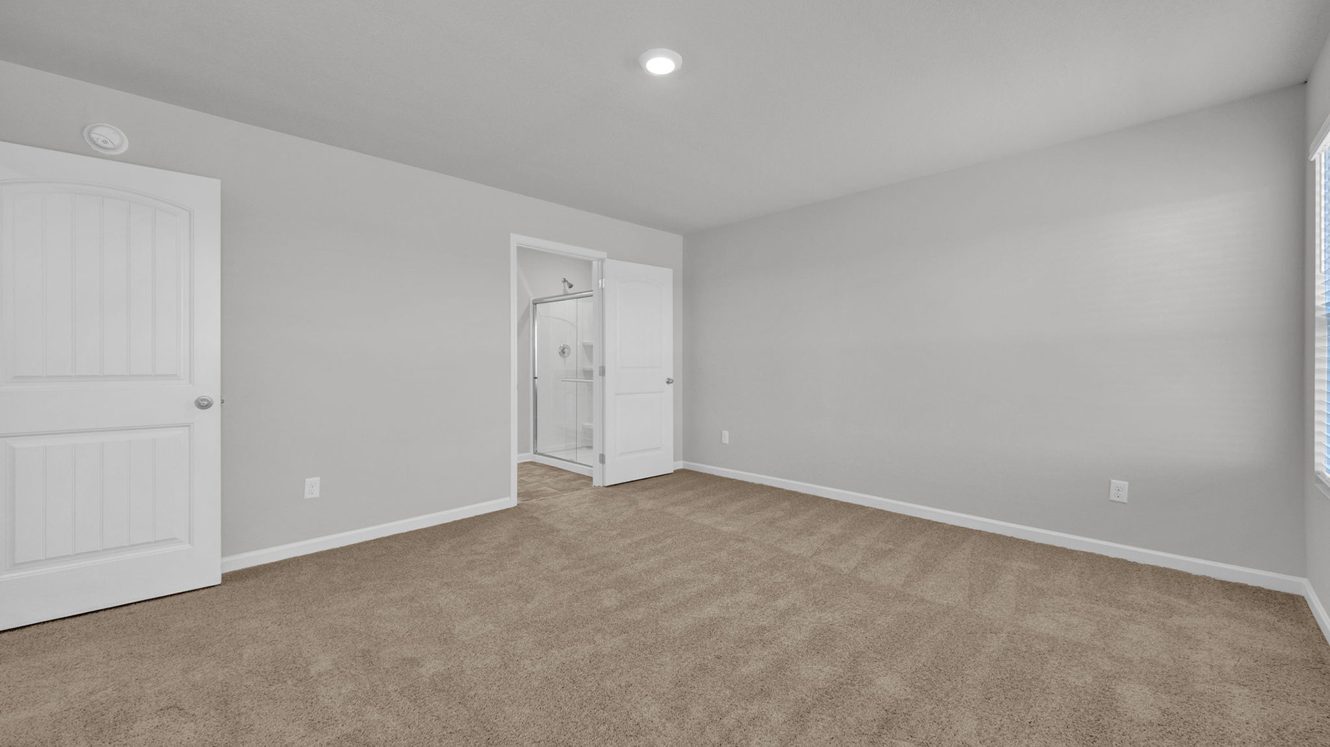 Primary bedroom with carpet flooring and neutral paint