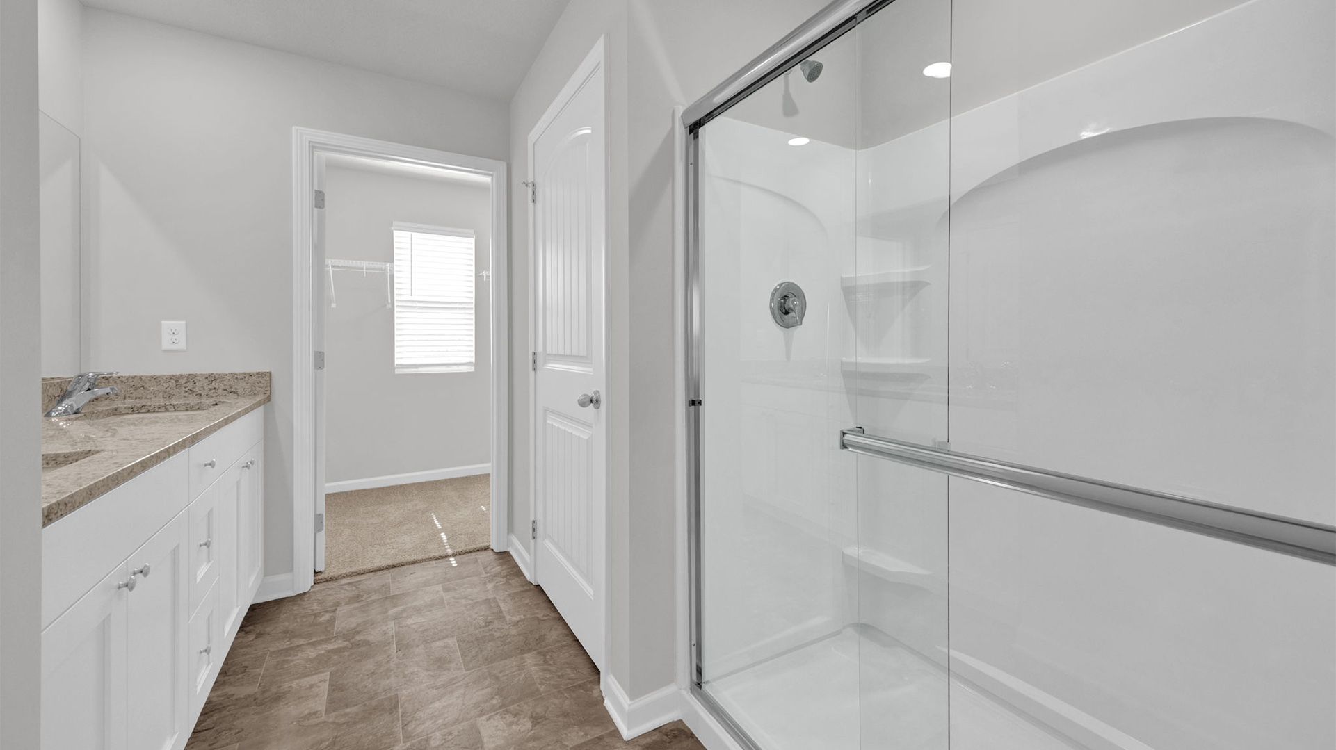 Glass enclosed walk in shower in primary bathroom