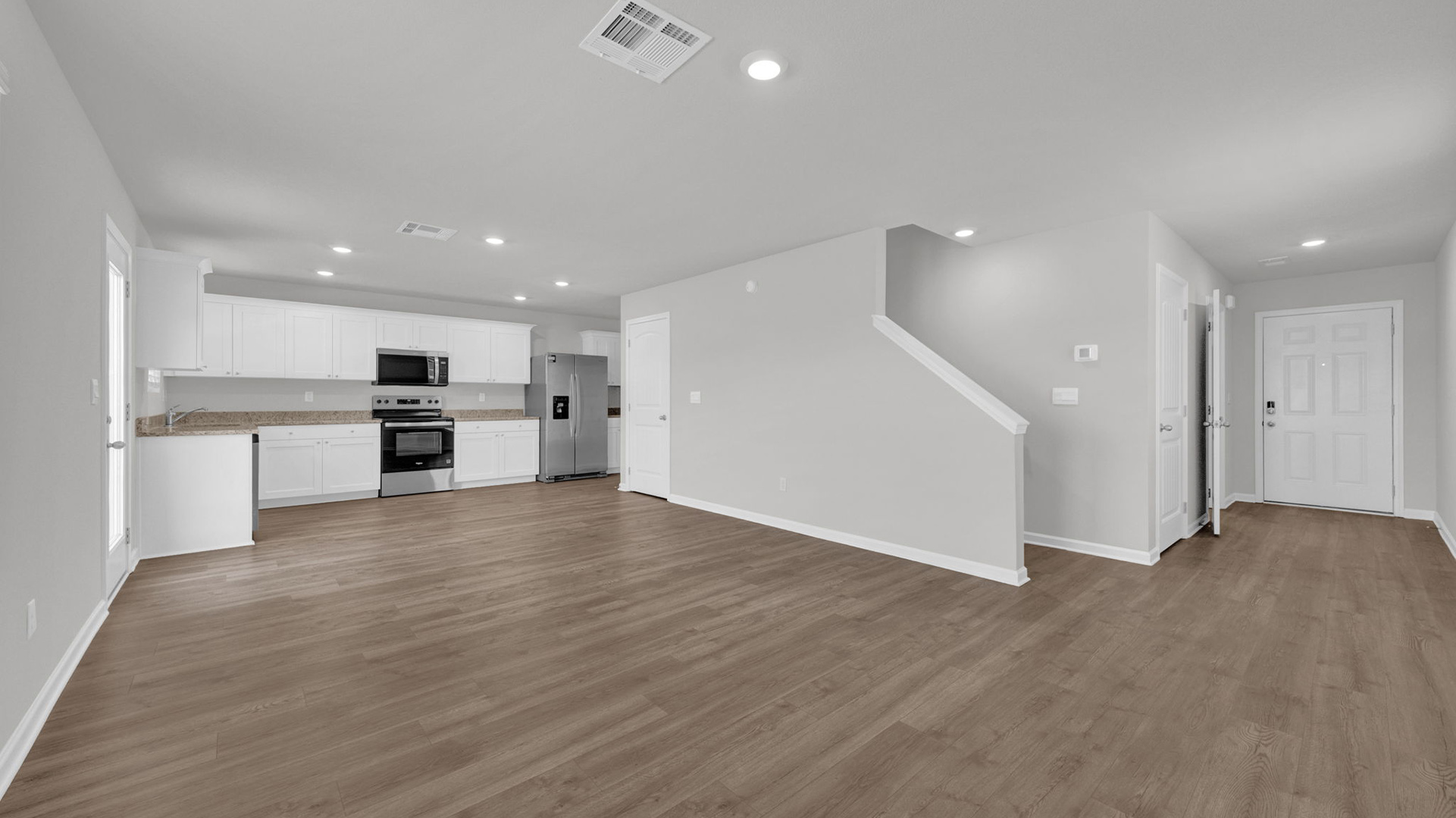 Open concept view of the main living area with vinyl flooring and neutral paint