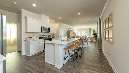 Beautiful kitchen area with light cabinets and stainless steel appliances