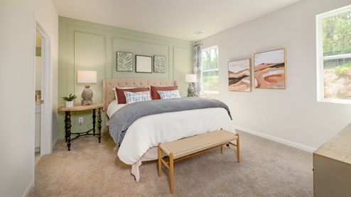 Primary bedroom with two windows overlooking the backyard