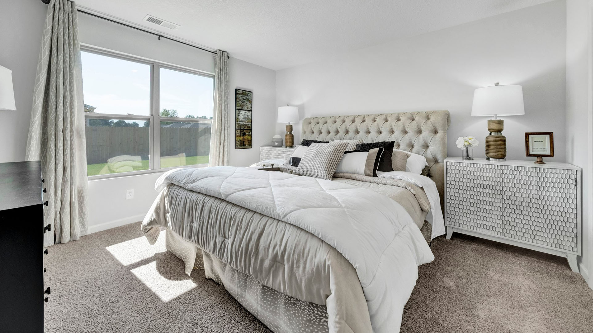 Beautiful primary bedroom with a double window overlooking the backyard