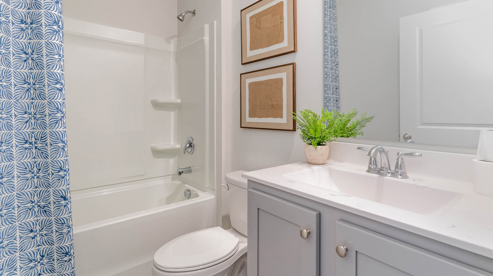 second bathroom with mirror over single vanity and an acrylic shower/tub insert