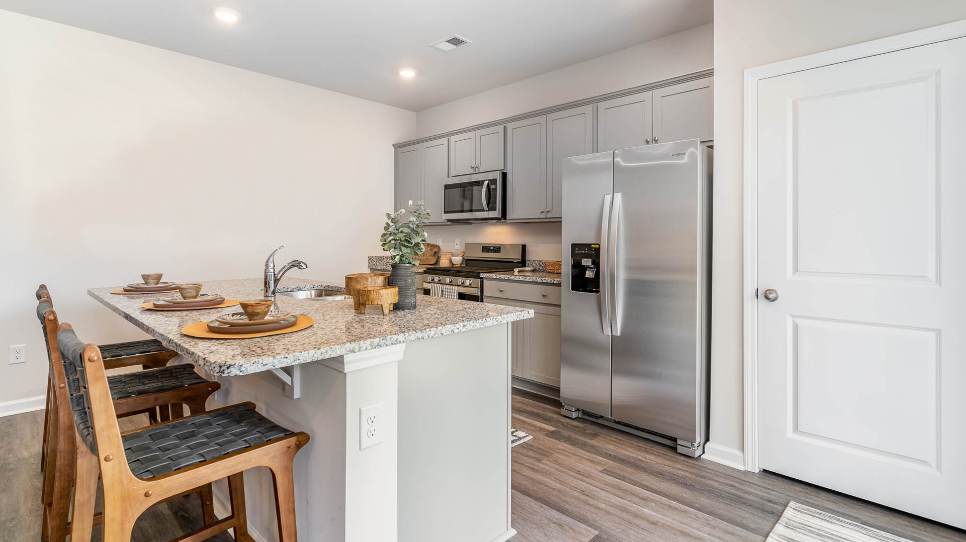 kitchen with granite counters, light cabinets, and stainless steel appliances