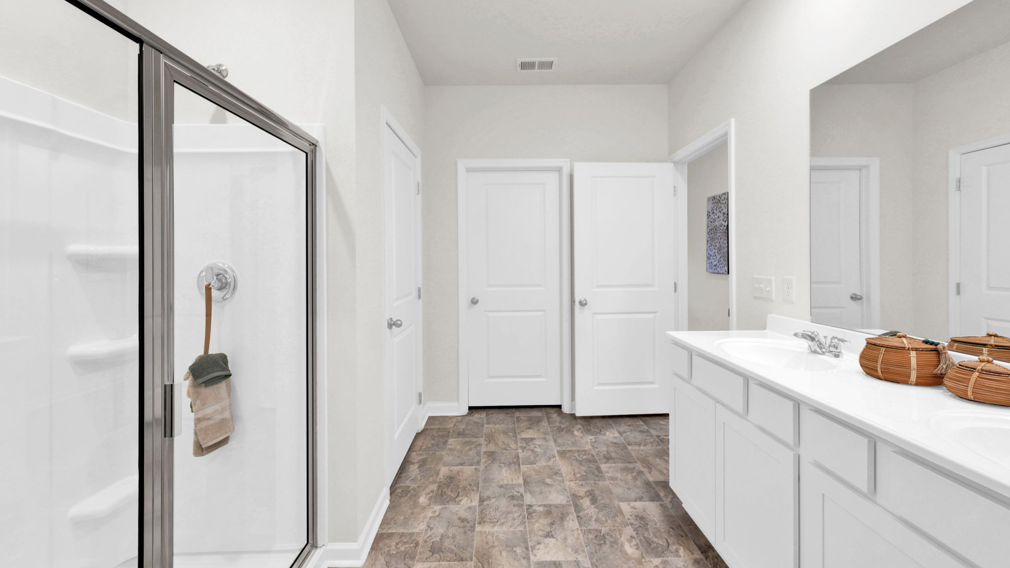 primary bathroom with double vanity and walk-in shower