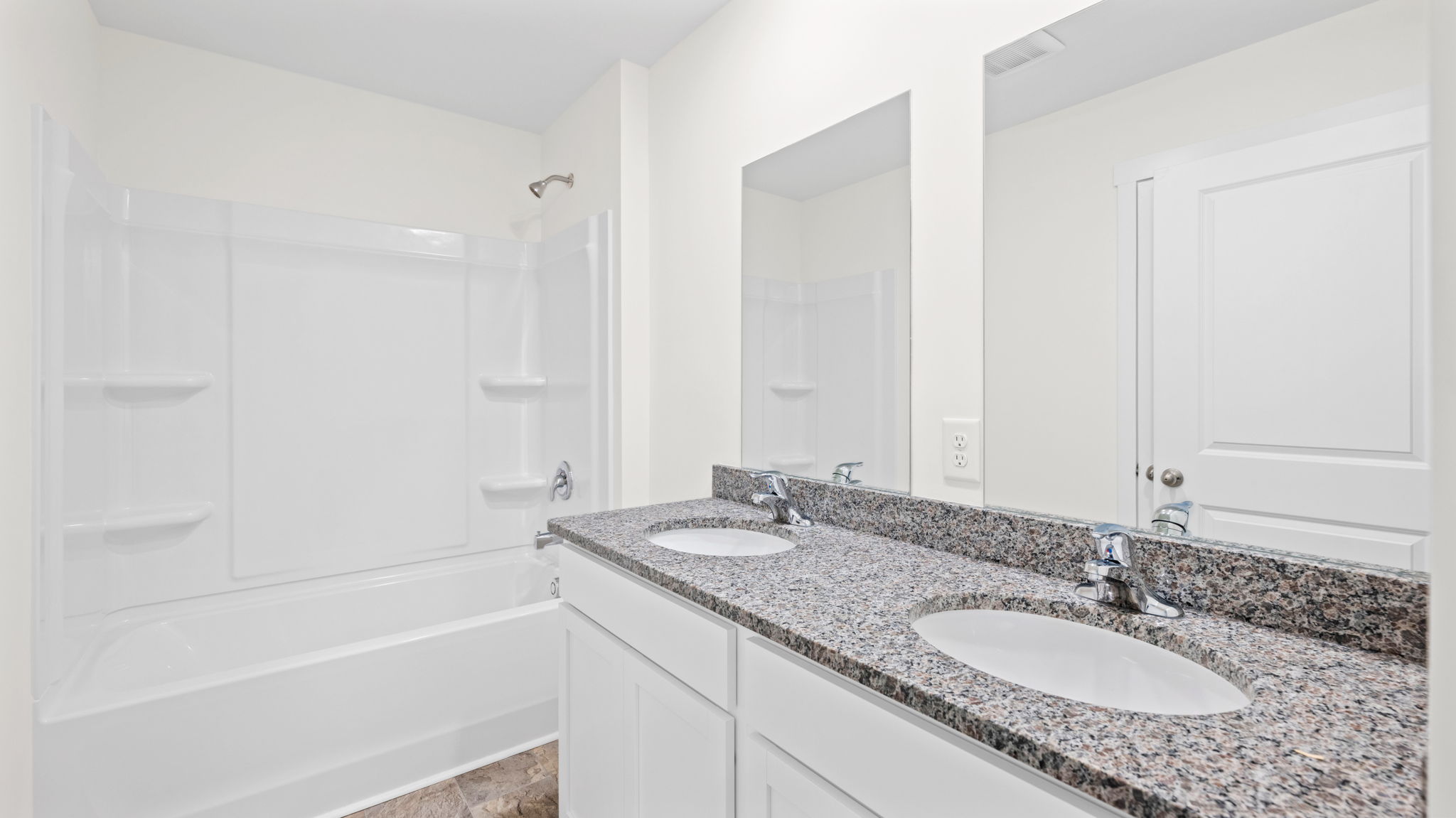 bathroom with double vanity and shower/ tub duo