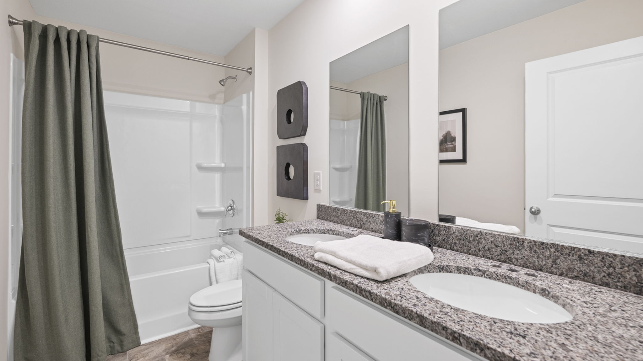 bathroom with double vanity and shower/ tub duo