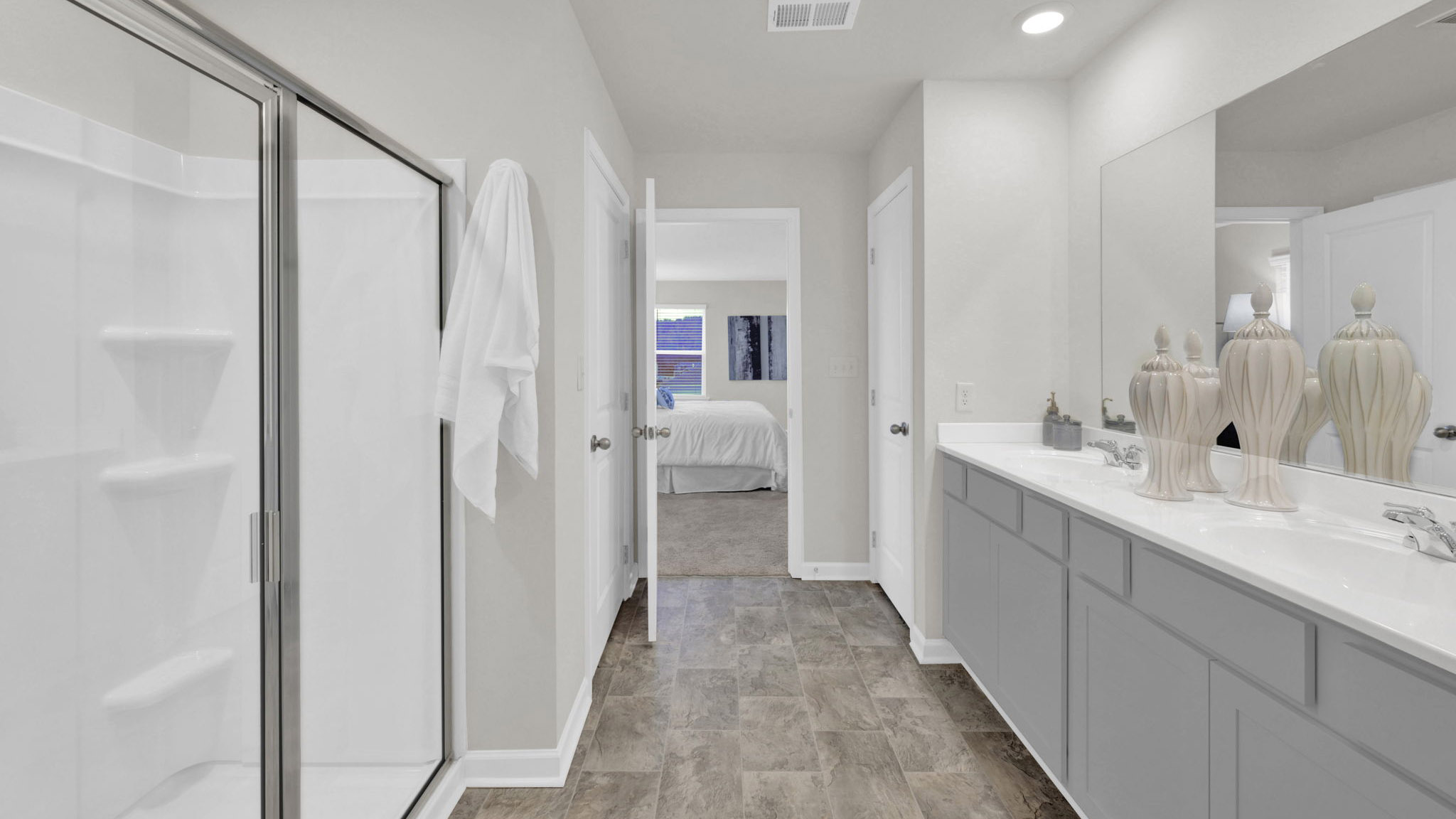 primary bathroom with double vanity and walk-in shower