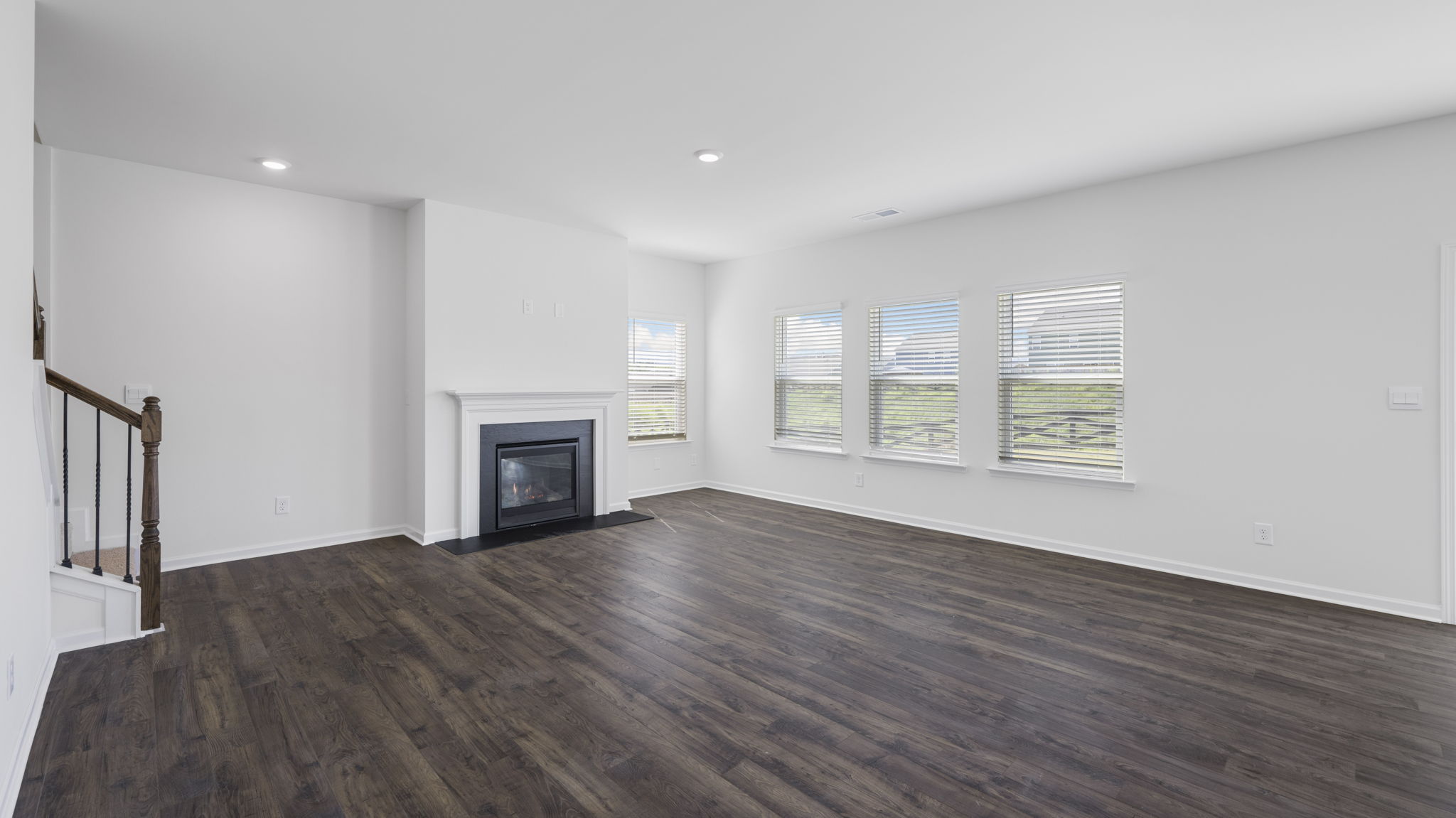 open concept living area with triple window and fireplace