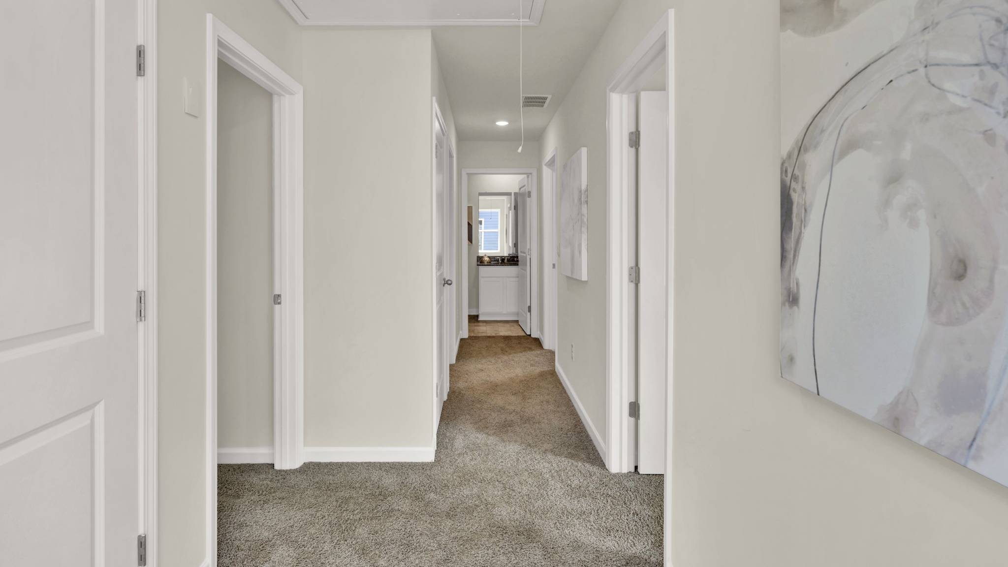 hallway with open doors and white walls