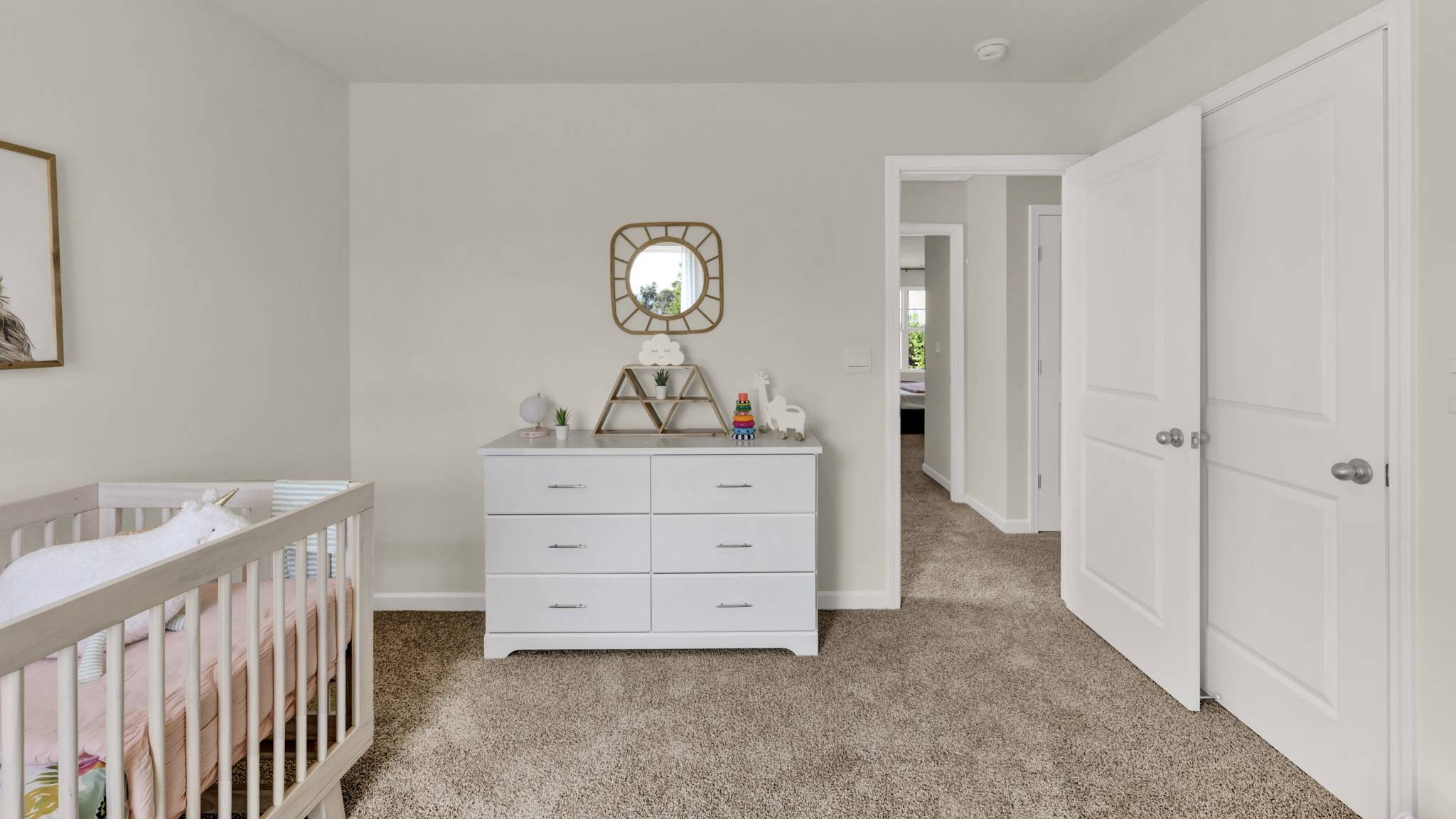 bedroom with white dresser and open door