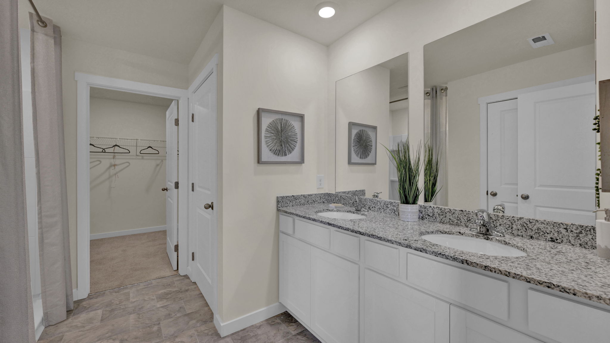 primary bathroom with double vanity and walk-in closet