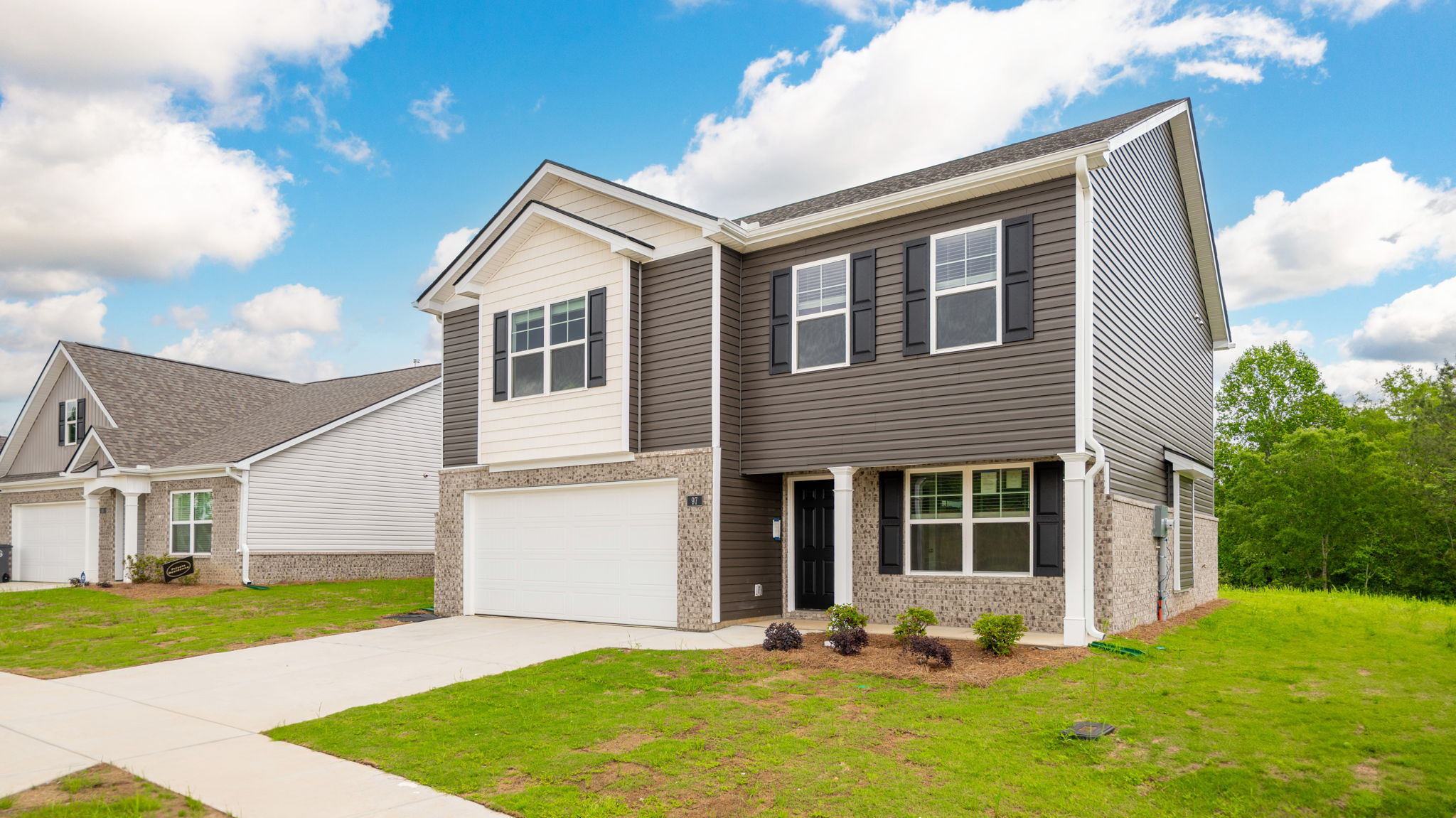Two story home with two car garage and brick and vinyl