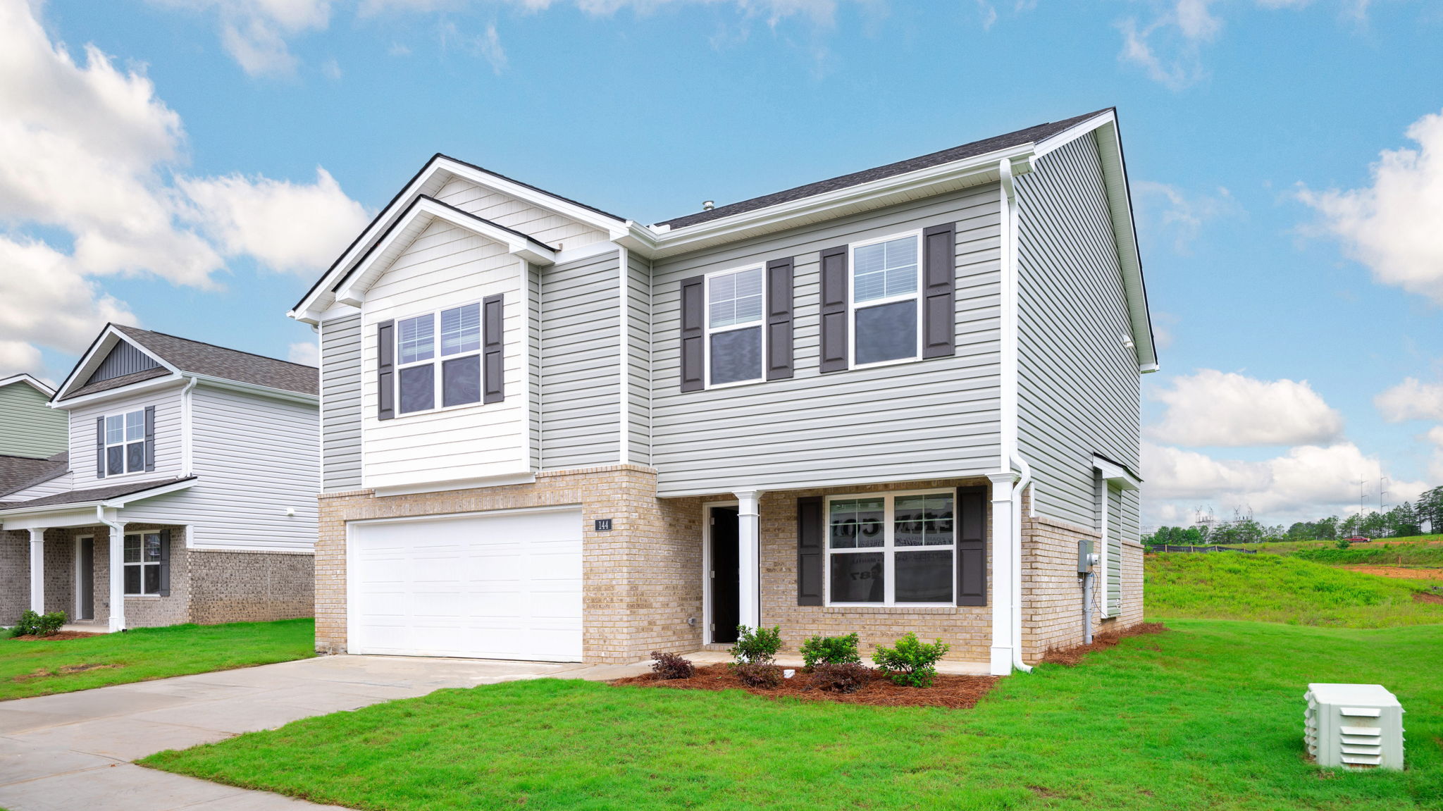 Two story home with light exteriors and two car garage.