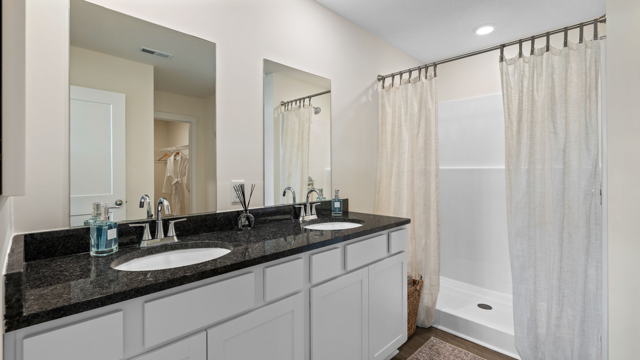 primary bathroom with double vanity and walk-in shower