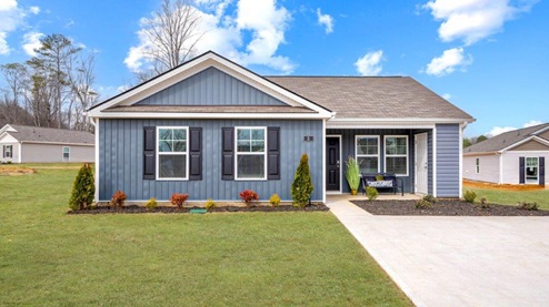 Exterior of one story home with deep blue siding and black shutters