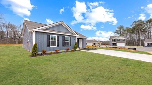 Exterior of one story home with deep blue siding and black shutters