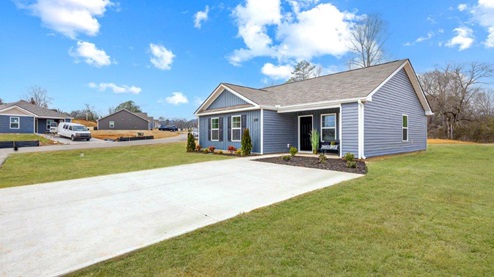 Exterior of one story home with deep blue siding and black shutters