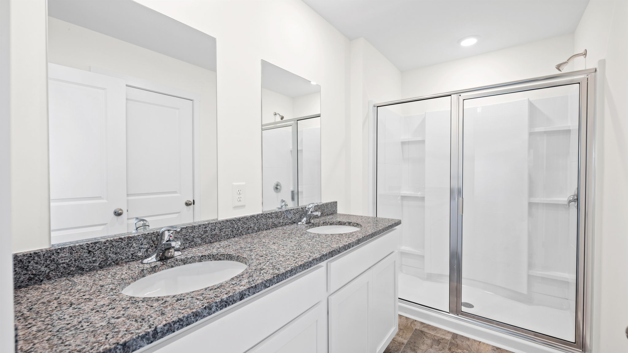 bathroom with double vanity and walk-in shower