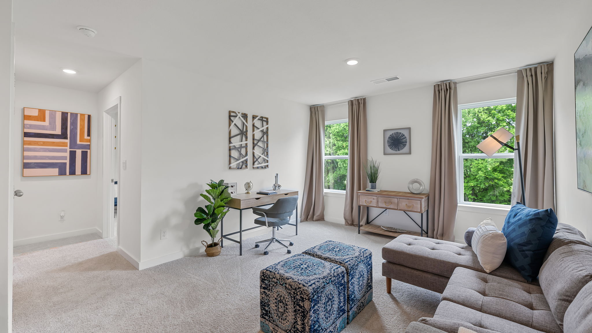 the living room has large windows with curtains