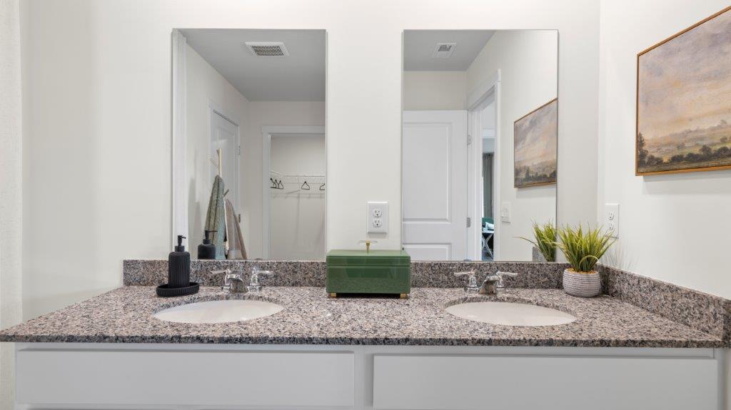 bathroom with dual sinks and mirror