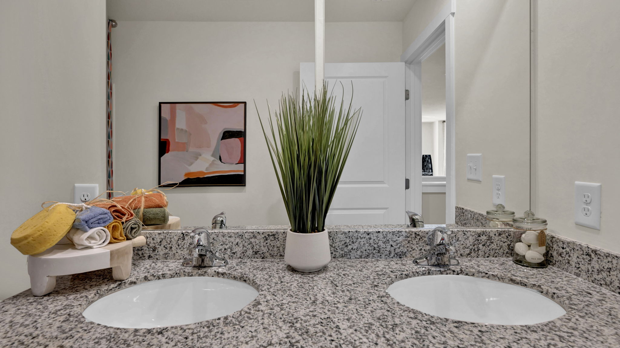 the bathroom has a solid surface and two sinks and mirror