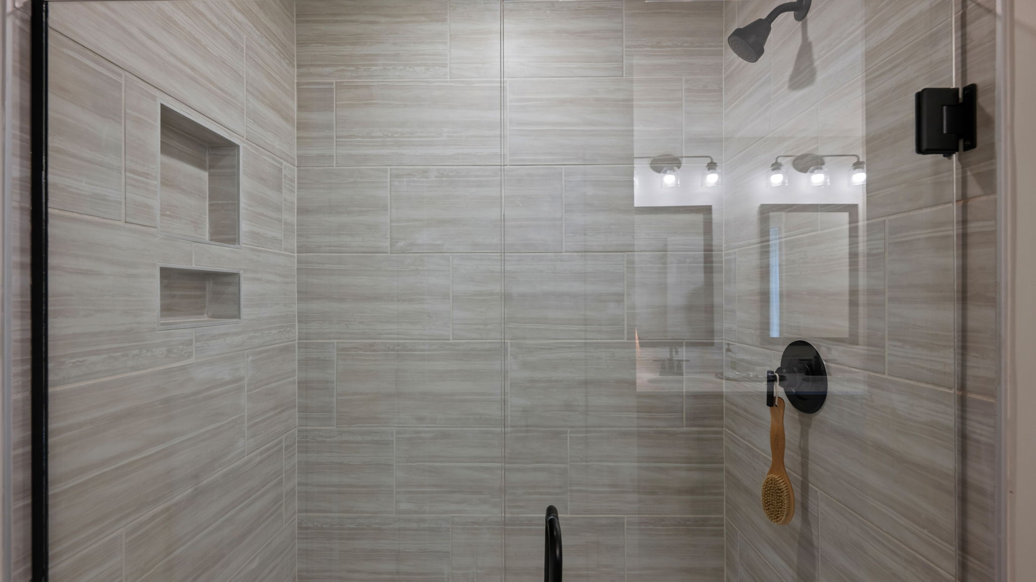 Primary bathroom with glass shower door and wfloor and wall tile