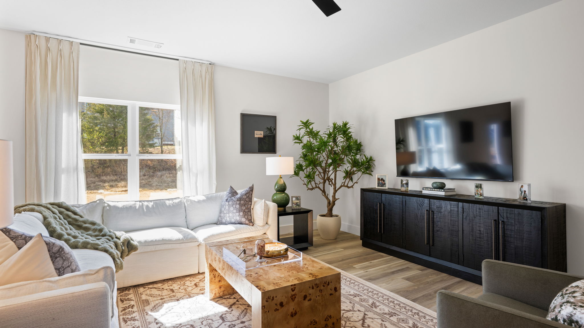 Living room with ceiling fan and double window