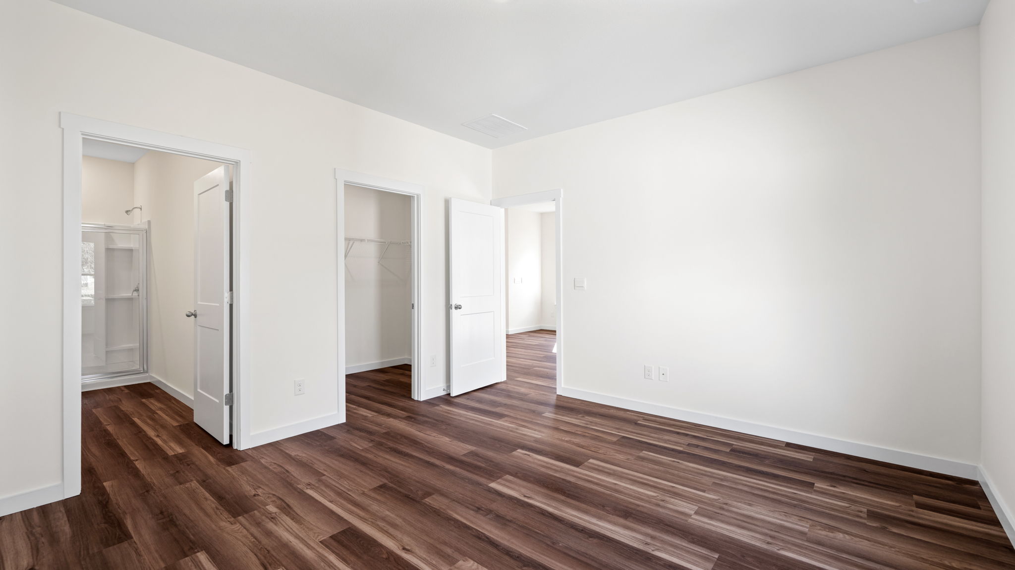 bedroom with open doors and lvp flooring