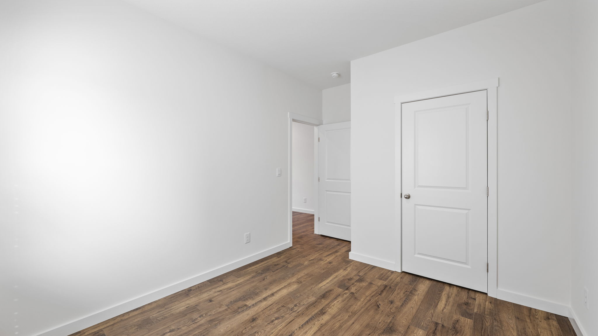 bedroom with lvp flooring and doors