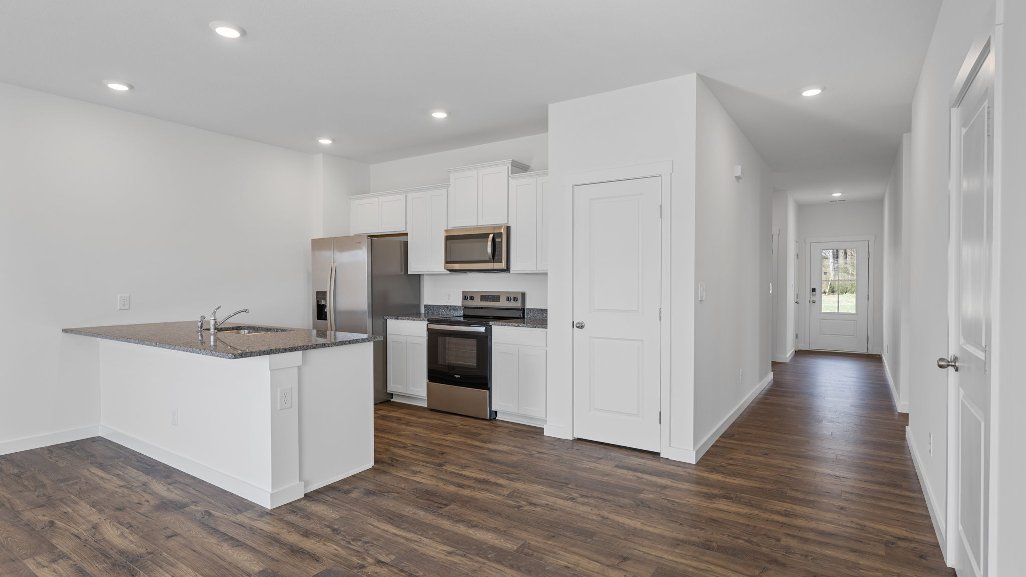 kitchen with island and appliances and open hallway