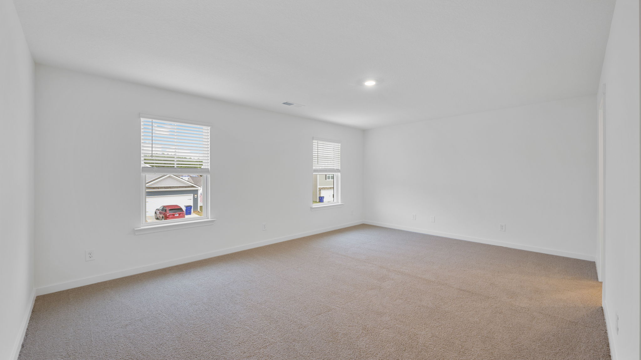 primary bedroom with two windows and carpet