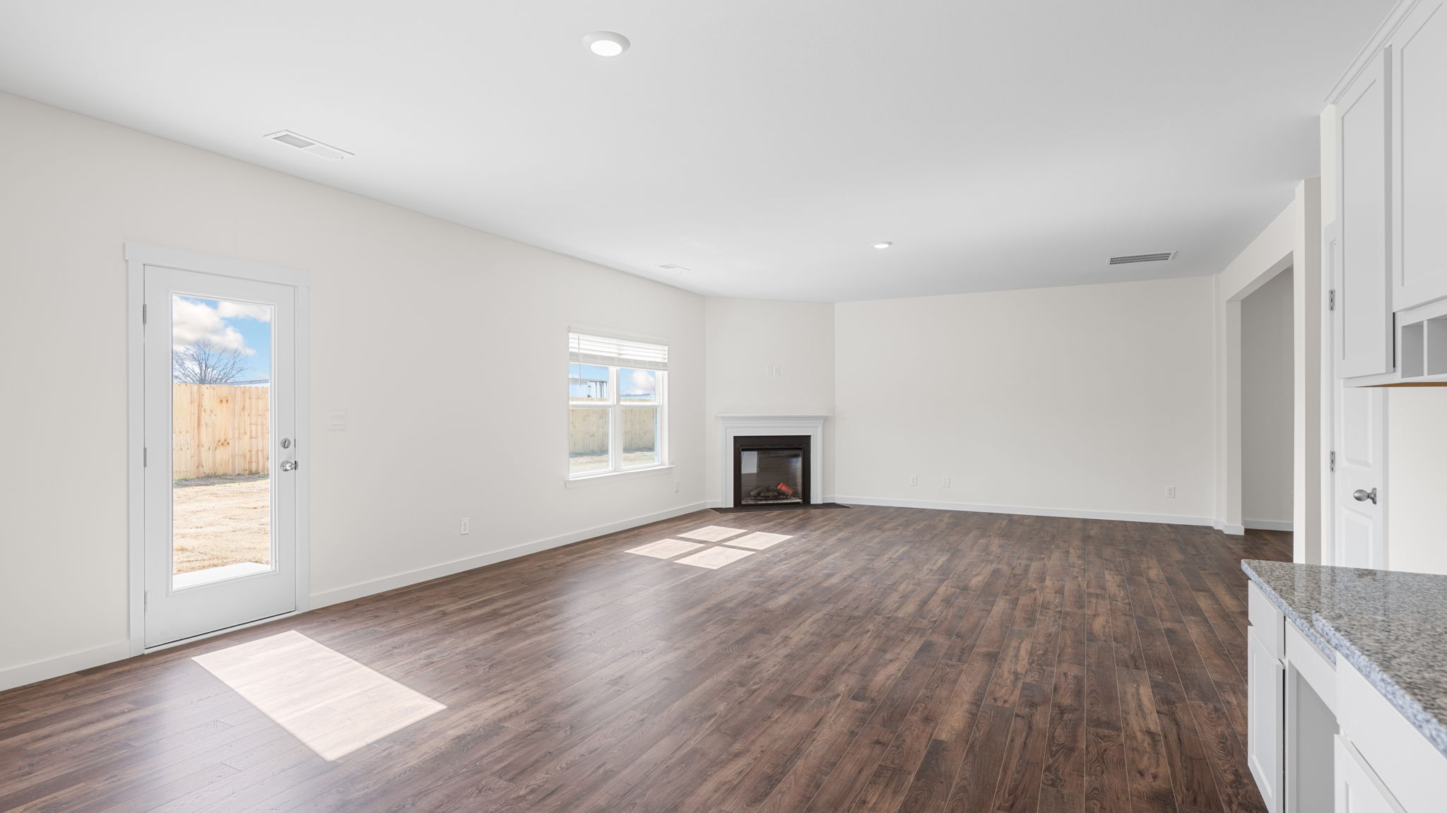 great room with solid flooring and fireplace