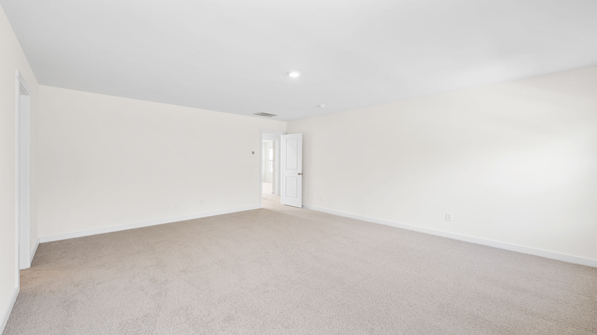 primary bedroom with two windows and open door